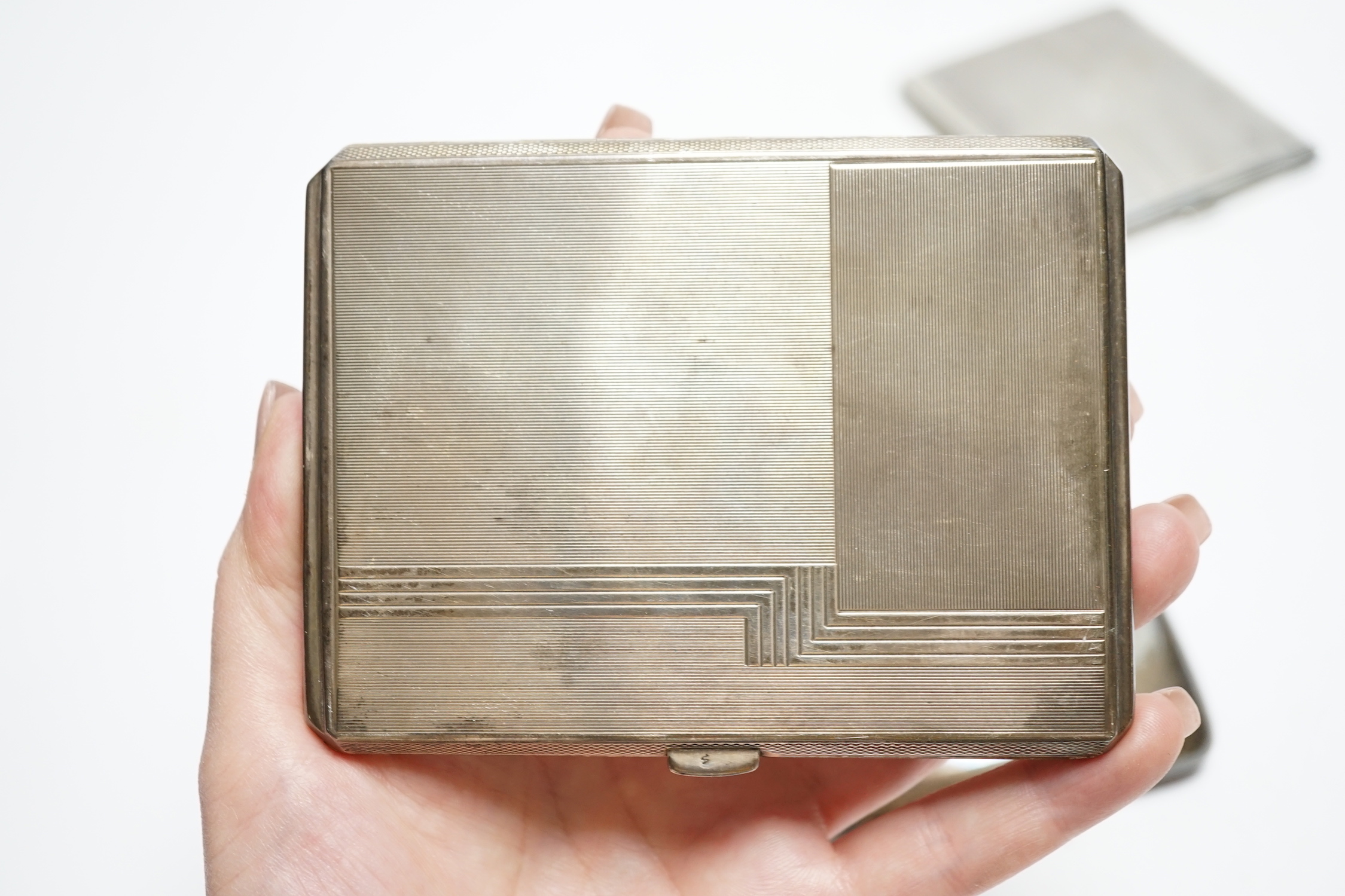 Three silver cigarette cases, including two Art Deco, largest 11.4cm.